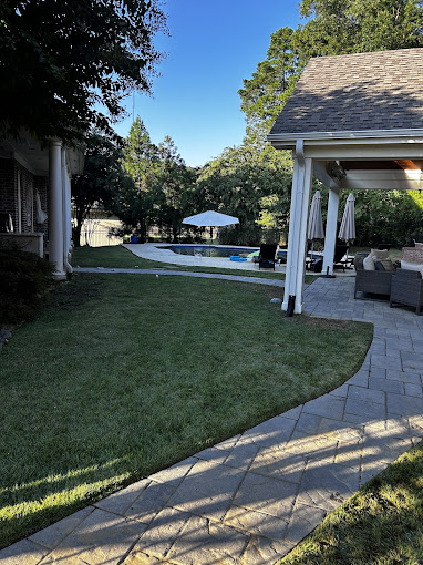 A backyard with a pool and a covered patio